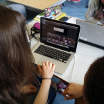 Students editing their film footage on iMovie using a Macbook Pro. (faces blurred to maintain privacy)