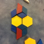 Using pattern blocks to create a symmetrical design.