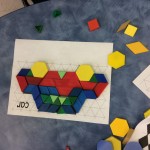 Using pattern blocks to fill in a puzzle mu.