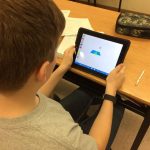 Students using iPads to visualize and compare fractions